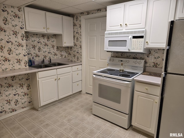 2704 Kings Pointe NE Unit 2704, Quincy, IL 62305 - kitchen with a drop ceiling, wallpapered walls, white appliances, a sink, and white cabinets