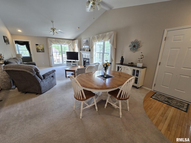2704 Kings Pointe NE Unit 2704, Quincy, IL 62305 - dining room featuring a ceiling fan, vaulted ceiling, a glass covered fireplace, and light wood finished floors