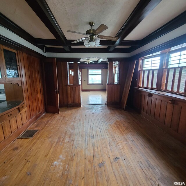 207 W Main St, Knoxville, IL 61448 - spare room featuring light wood finished floors, a ceiling fan, visible vents, beamed ceiling, and wooden walls
