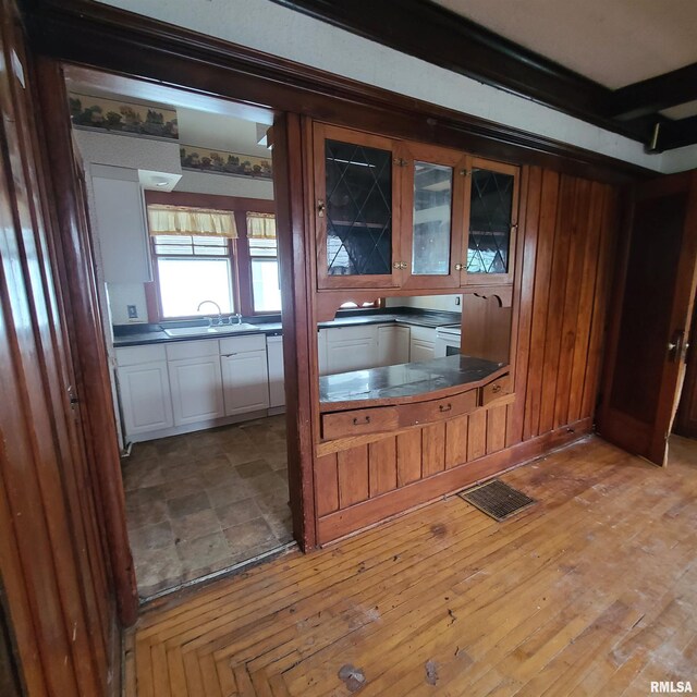 207 W Main St, Knoxville, IL 61448 - kitchen featuring a sink, visible vents, glass insert cabinets, white cabinets, and dark countertops