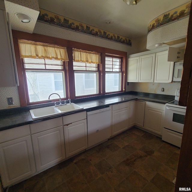 207 W Main St, Knoxville, IL 61448 - kitchen featuring a sink, white appliances, dark countertops, and white cabinets