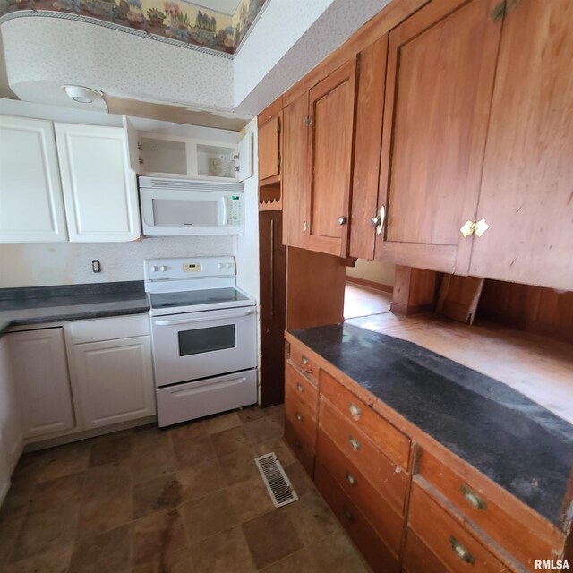 207 W Main St, Knoxville, IL 61448 - kitchen with brown cabinetry, white appliances, visible vents, dark countertops, and wallpapered walls