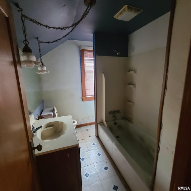 207 W Main St, Knoxville, IL 61448 - bathroom featuring lofted ceiling, toilet, vanity, tile patterned flooring, and tub / shower combination