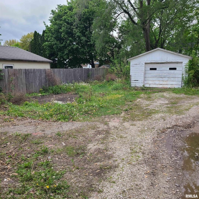 207 W Main St, Knoxville, IL 61448 - view of yard with dirt driveway, fence, a garage, and an outbuilding