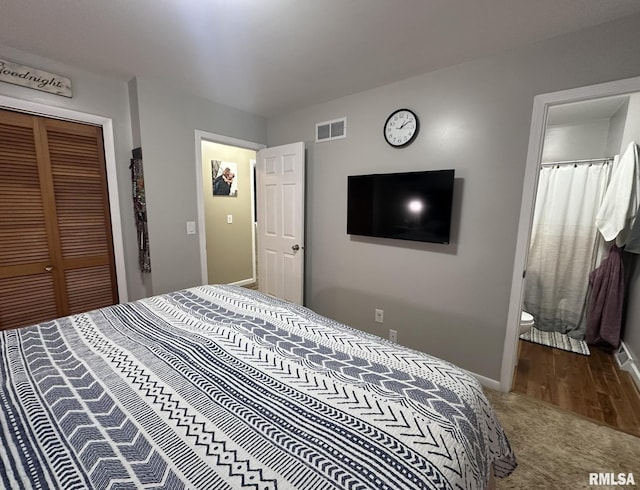 carpeted bedroom featuring ensuite bathroom, baseboards, a closet, and visible vents