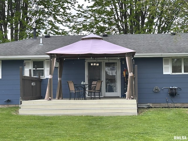 back of property featuring a lawn and a shingled roof