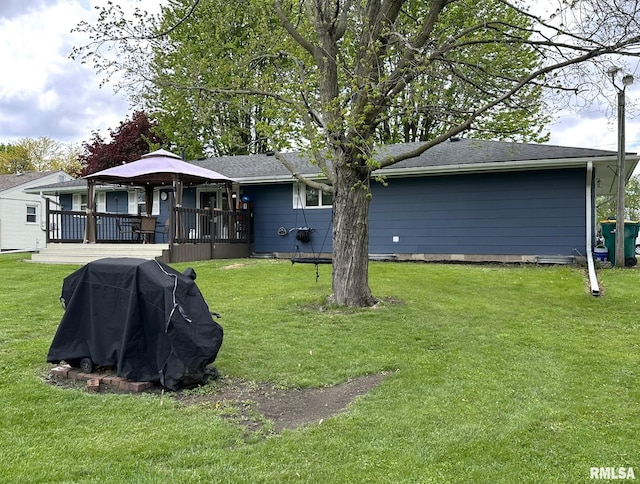 back of property with a lawn, a gazebo, and a wooden deck