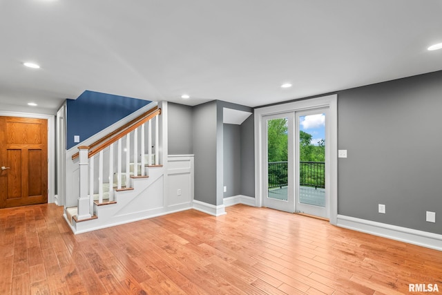 interior space featuring baseboards, light wood-style floors, recessed lighting, and stairway