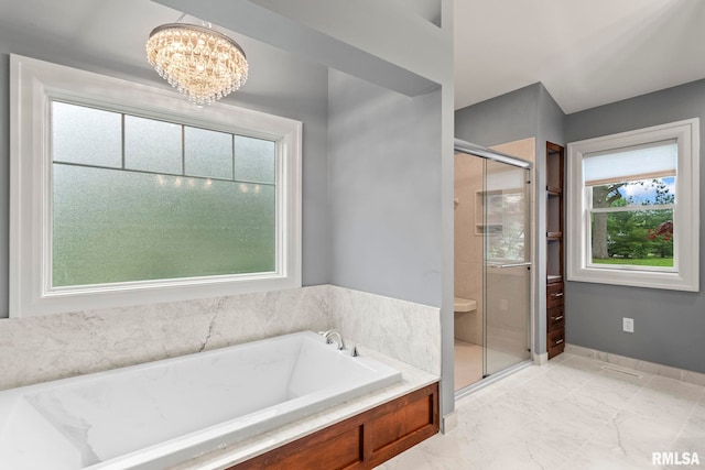 bathroom with a stall shower, a garden tub, and a chandelier