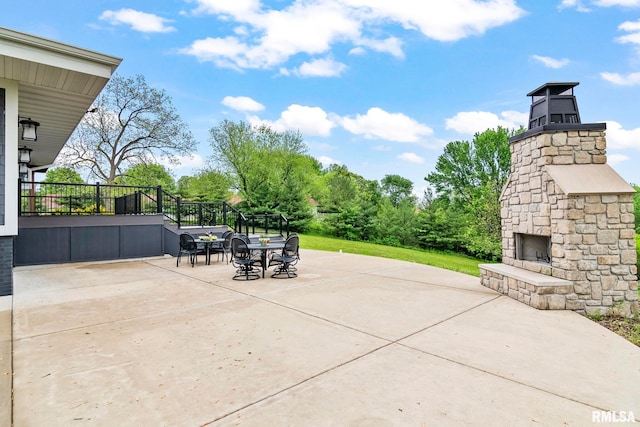 view of patio / terrace with an outdoor stone fireplace and outdoor dining area