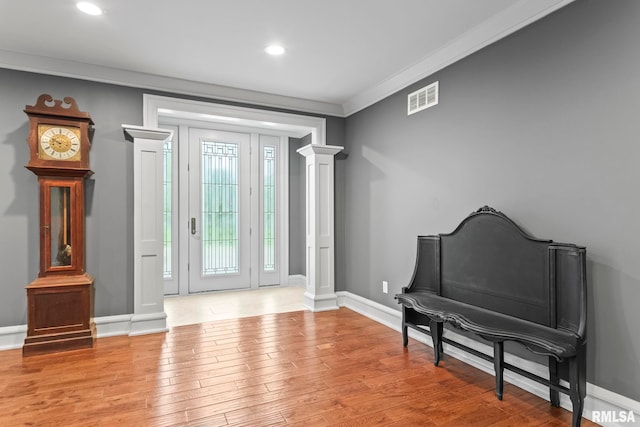 foyer with wood finished floors, ornate columns, visible vents, baseboards, and recessed lighting