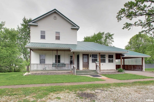 farmhouse inspired home with metal roof, a porch, concrete driveway, an attached carport, and a front lawn