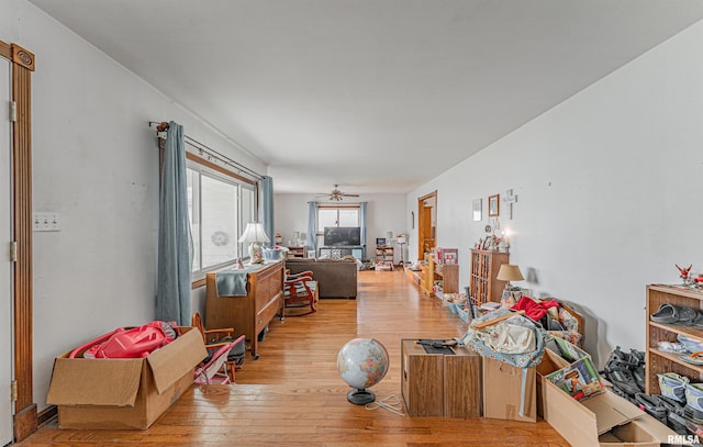 living area with a ceiling fan and hardwood / wood-style flooring