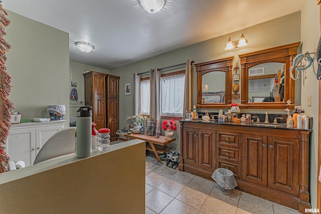 bathroom featuring a sink, double vanity, visible vents, and tile patterned flooring