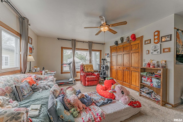 living room featuring carpet, baseboards, and a ceiling fan