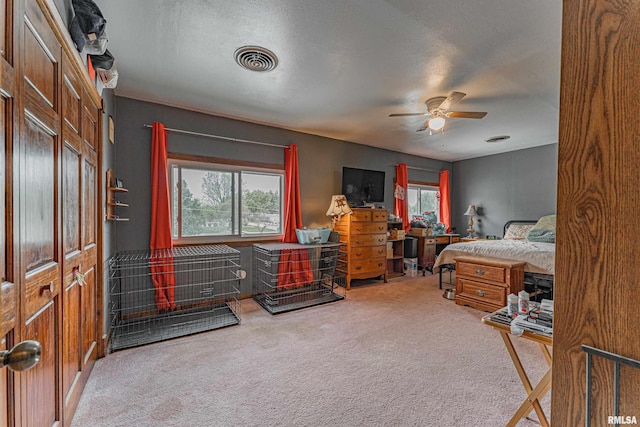 bedroom with carpet, a textured ceiling, visible vents, and a ceiling fan