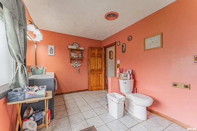 bathroom with toilet, tile patterned flooring, visible vents, and baseboards