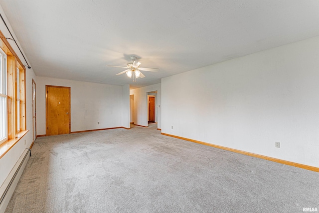 unfurnished room featuring baseboards, baseboard heating, ceiling fan, and light colored carpet