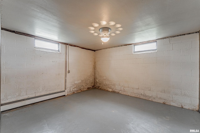 basement with a baseboard radiator and a healthy amount of sunlight