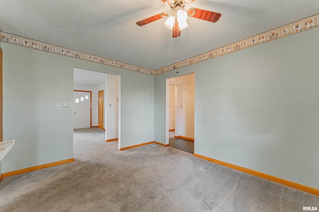 carpeted empty room featuring a textured ceiling, baseboards, and a ceiling fan