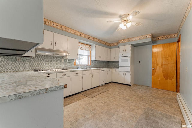 kitchen featuring white appliances, under cabinet range hood, a warming drawer, a ceiling fan, and baseboard heating
