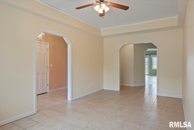 spare room with ceiling fan, light tile patterned floors, and arched walkways