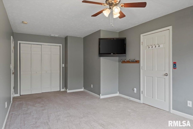 unfurnished bedroom featuring light colored carpet, a closet, and baseboards