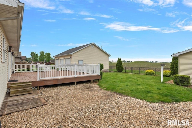 view of yard featuring fence, a deck, and a garage