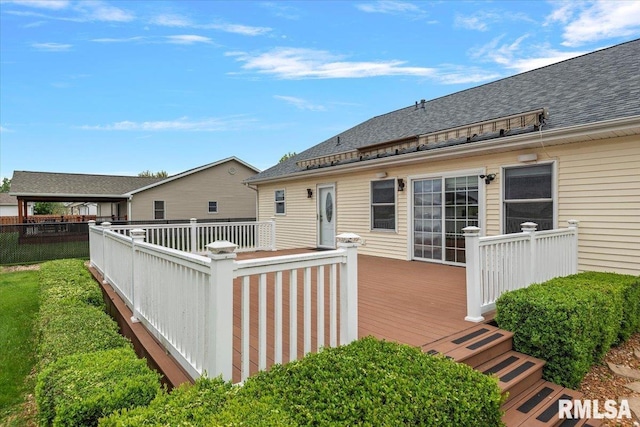 rear view of property with a shingled roof, a lawn, fence, and a wooden deck