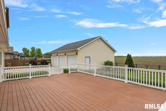 wooden deck featuring an outdoor structure, a garage, and fence