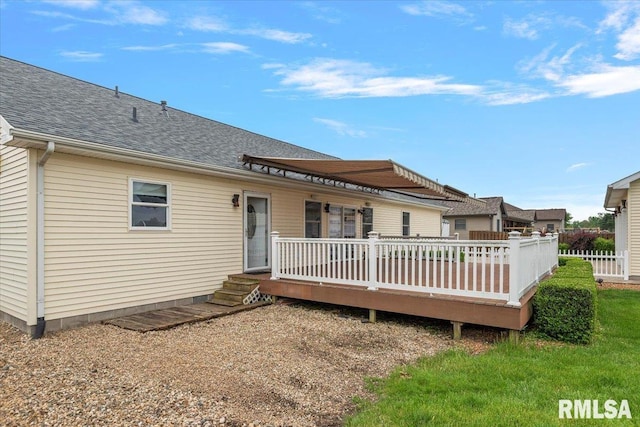 rear view of property with a wooden deck and a shingled roof