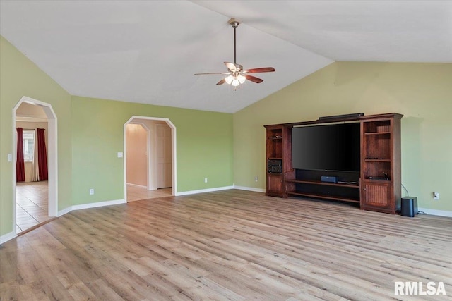 unfurnished living room with lofted ceiling, light wood-style flooring, arched walkways, and a ceiling fan