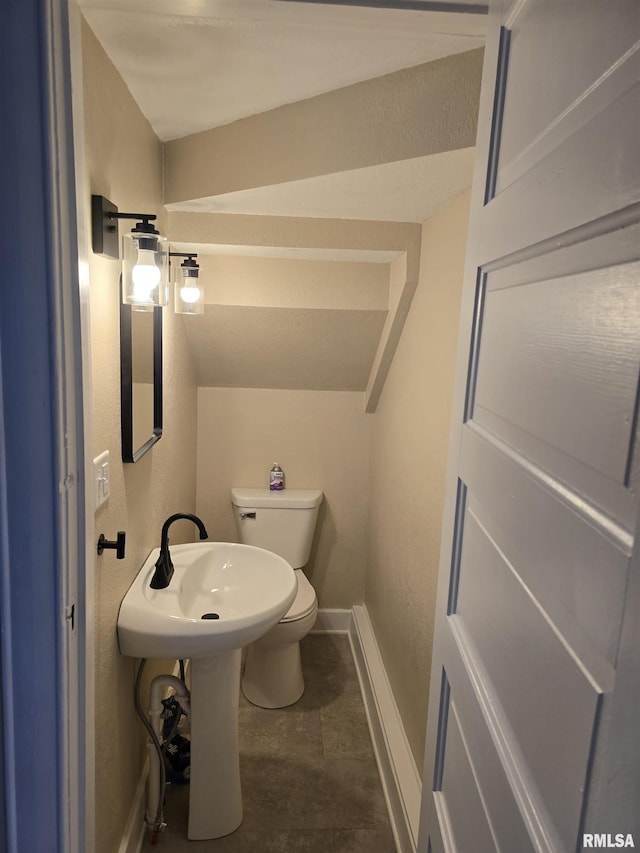 half bathroom featuring baseboards and toilet