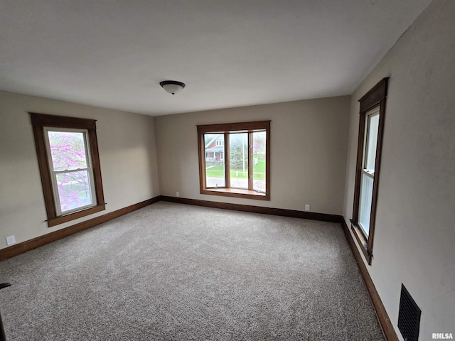 unfurnished room featuring carpet flooring, baseboards, and visible vents