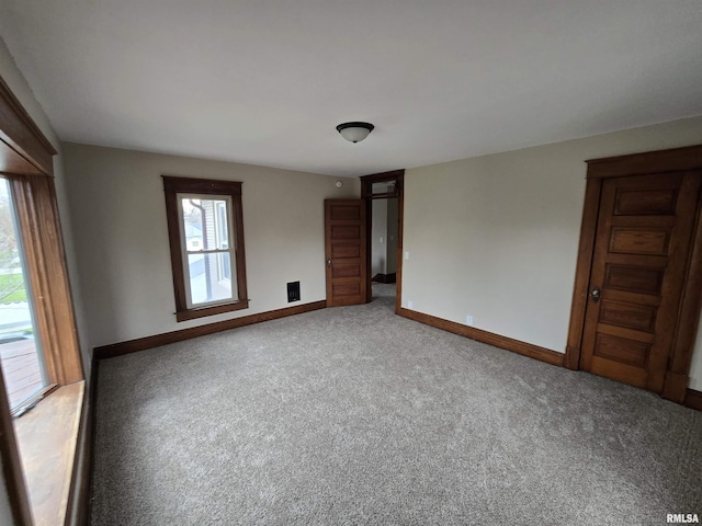 empty room featuring light colored carpet and baseboards