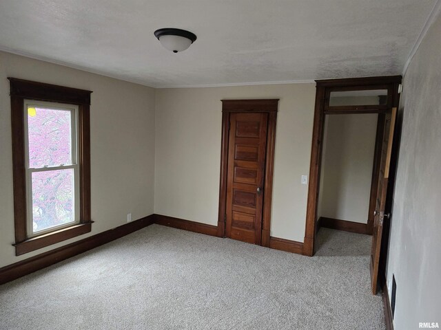 unfurnished bedroom featuring ornamental molding, carpet, and baseboards