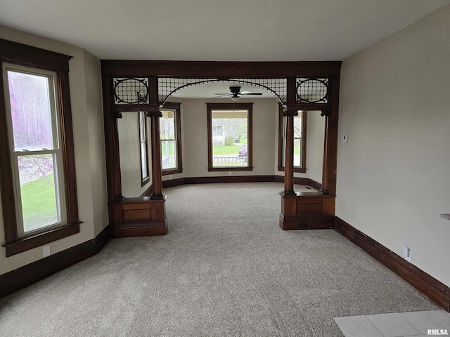 carpeted empty room featuring baseboards and a ceiling fan