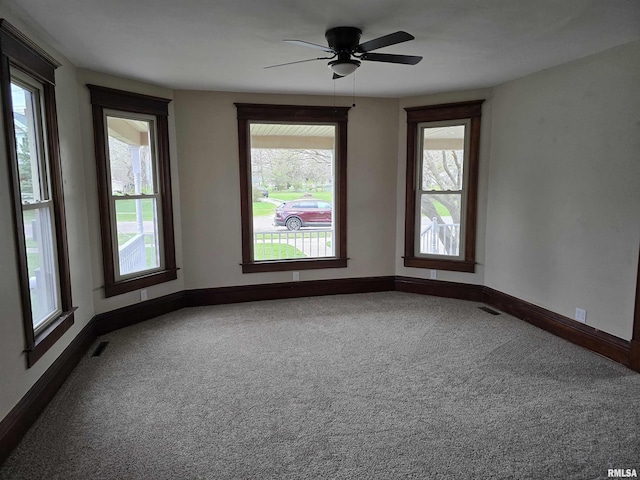 empty room featuring baseboards, visible vents, a ceiling fan, and carpet