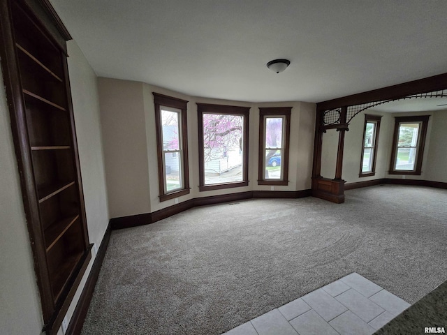 carpeted empty room with baseboards
