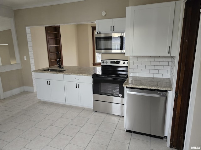 kitchen featuring light tile patterned floors, ornamental molding, backsplash, stainless steel appliances, and white cabinets