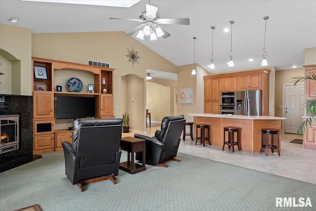 living room featuring ceiling fan, light carpet, visible vents, and high vaulted ceiling