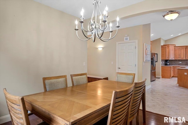 dining room with lofted ceiling, a notable chandelier, and visible vents