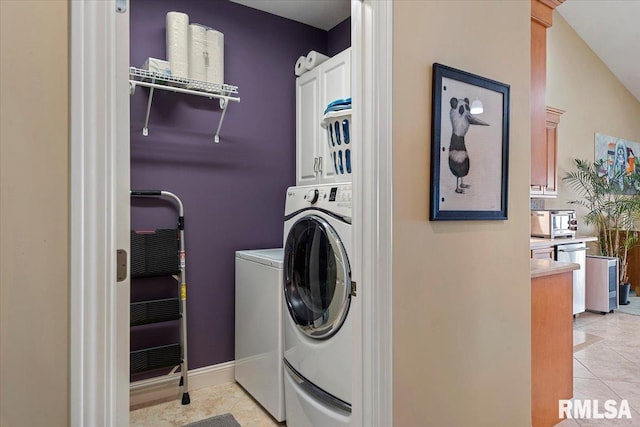 laundry room featuring light tile patterned floors, separate washer and dryer, and cabinet space