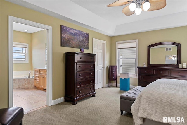 bedroom with a ceiling fan, visible vents, baseboards, ensuite bath, and light carpet