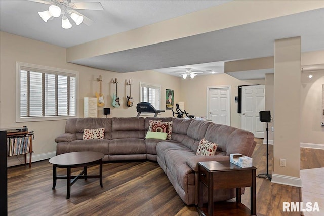 living area featuring baseboards, a ceiling fan, and dark wood-style floors