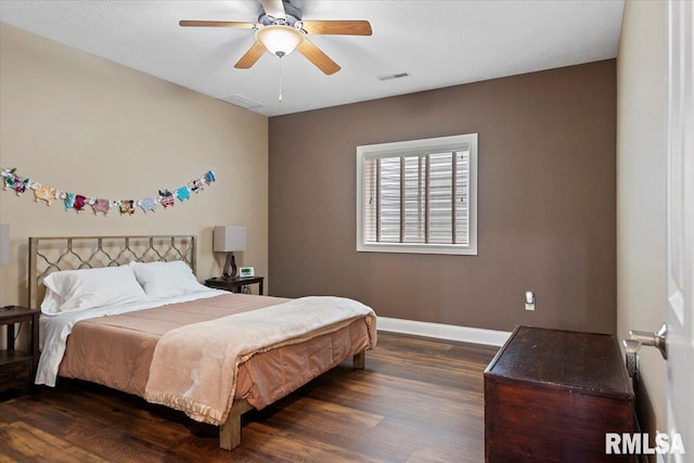bedroom with dark wood finished floors, visible vents, baseboards, and ceiling fan