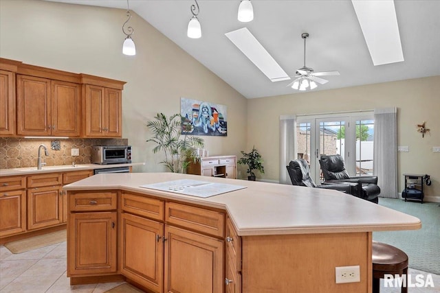 kitchen featuring a sink, a skylight, and light countertops