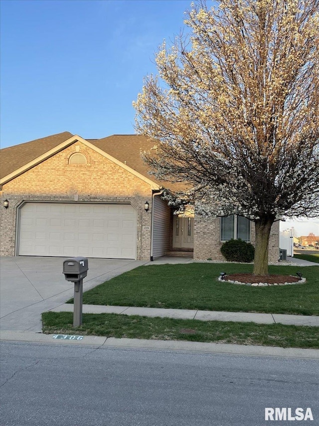 ranch-style home with an attached garage, concrete driveway, brick siding, and a front lawn