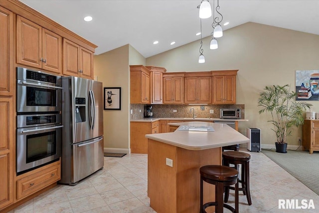 kitchen with light tile patterned floors, light countertops, tasteful backsplash, and appliances with stainless steel finishes