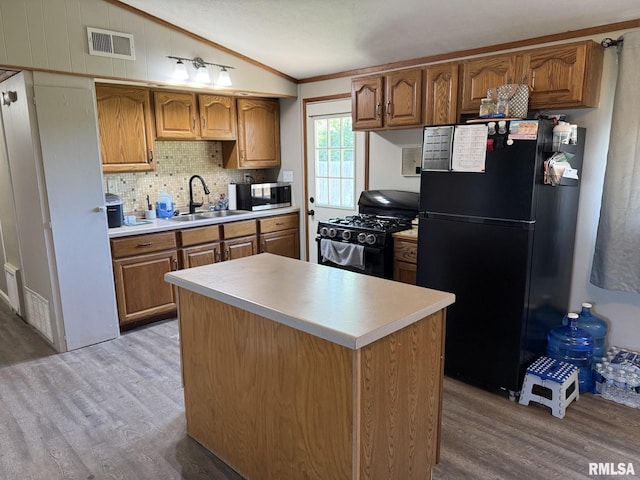 176 Lakeview Dr, Wataga, IL 61488 - kitchen featuring black appliances, vaulted ceiling, a sink, wood finished floors, and tasteful backsplash